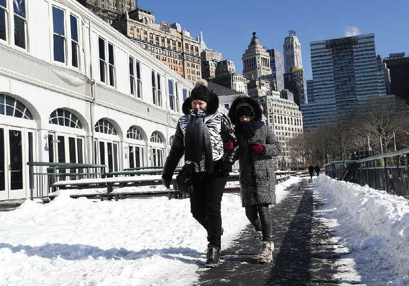 Katherine Rozenbert and her granddaughter Rebecca, both of Paris, walk in Battery Park City on Sunday in New York after their return flight from John F. Kennedy International Airport, scheduled for Friday, was canceled because of bad weather.