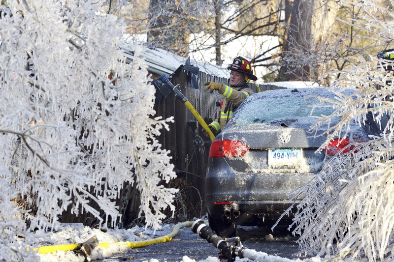 FILE - In this Jan. 5, 2018, file photo, a firefighter from the Longmeadow Fire Department battles a house fire in Longmeadow, Mass. Firefighters battling blazes in the extreme cold are faced with treacherous conditions, frozen hydrants and slick surfaces that make an already difficult job even harder. Departments in colder climates prepare months ahead for the coming freeze, readying equipment and changing how they approach fires in the coldest months. (Dave Roback/The Republican via AP, File)