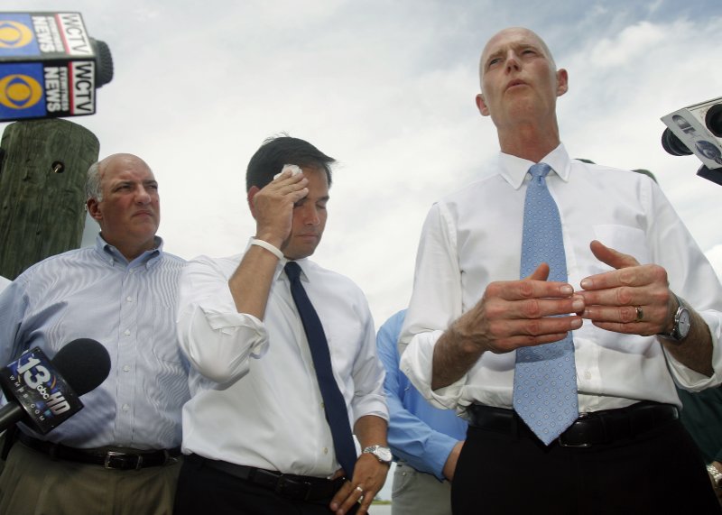 FILE - In this Aug. 13, 2013, file photo, Rep. Steve Southerland, R-Fla. and Sen. Marco Rubio listen to Florida Gov. Rick Scott announce a lawsuit against the state of Georgia, while touring Apalachicola, Fla. Florida is hoping the Supreme Court will come to the rescue of this slice of northwestern Florida, which the state says has been devastated by greedy water users in Georgia. The high court hears argument Monday, Jan. 8, 2018, in the long-running water war between the neighboring states. (AP Photo/Phil Sears, File)