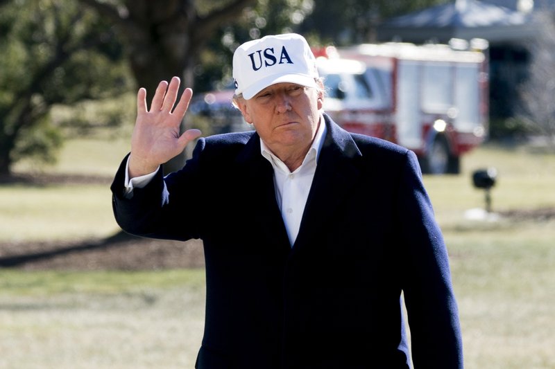 President Donald Trump waves to members of the media as he walks across the South Lawn as he arrives at the White House in Washington, Sunday, Jan. 7, 2018, after traveling from Camp David, Md. (AP Photo/Andrew Harnik)