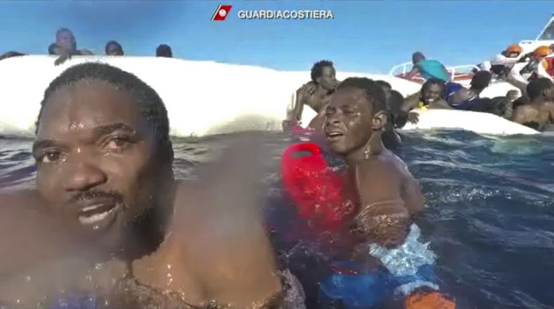 This frame of a video taken by the Italian Coast Guard on Jan. 6, 2018, in the Mediterranean Sea off Libya, shows migrants being rescued from dinghies as they try to cross to Italy. 
