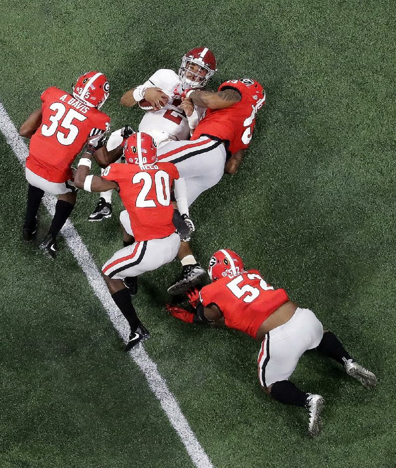 Alabama quarterback Jalen Hurts is sacked during the first half of the College Football Playoff national championship against Georgia on Monday in Atlanta. Hurts completed 3 of 8 passes for 21 yards and was replaced in the second half by Tua Tagovailoa, who threw for 166 yards and 3 touchdowns in leading Alabama
to a 26-23 victory.