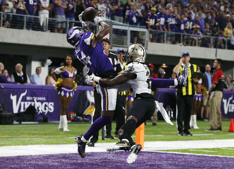 Minnesota Vikings wide receiver Stefon Diggs (left) catches a 2-yard touchdown pass over New Orleans Saints cornerback De’Vante Harris during the Vikings’ 29-19 victory on Sept. 11. The Saints and Vikings meet Sunday in the NFC divisional playoffs, but the Saints will have a different look as seven starters from the previous game won’t be playing this week.