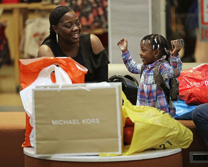 Mercedes Amos and her daughter Jhene Rivers, 2, of Orangeburg, S.C., rest after a day of Christmas shopping at a mall in Concord, N.C., in December. After a difficult year, many stores and malls are seeing signs that holiday sales were strong, but for many retailers results will not be available for a few more weeks. 
