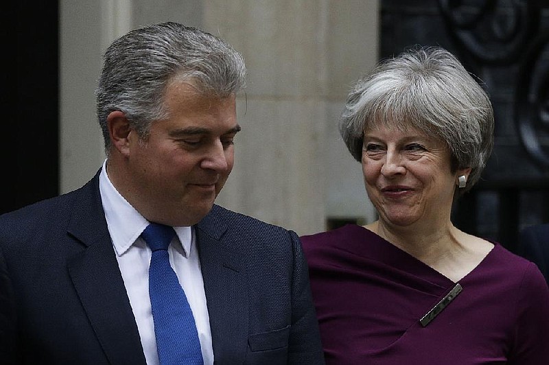 British Prime Minister Theresa May is joined by Brandon Lewis, the new chairman of the Conservative Party, at No. 10 Downing St. in London on Monday as she began to reshuffle her Cabinet.