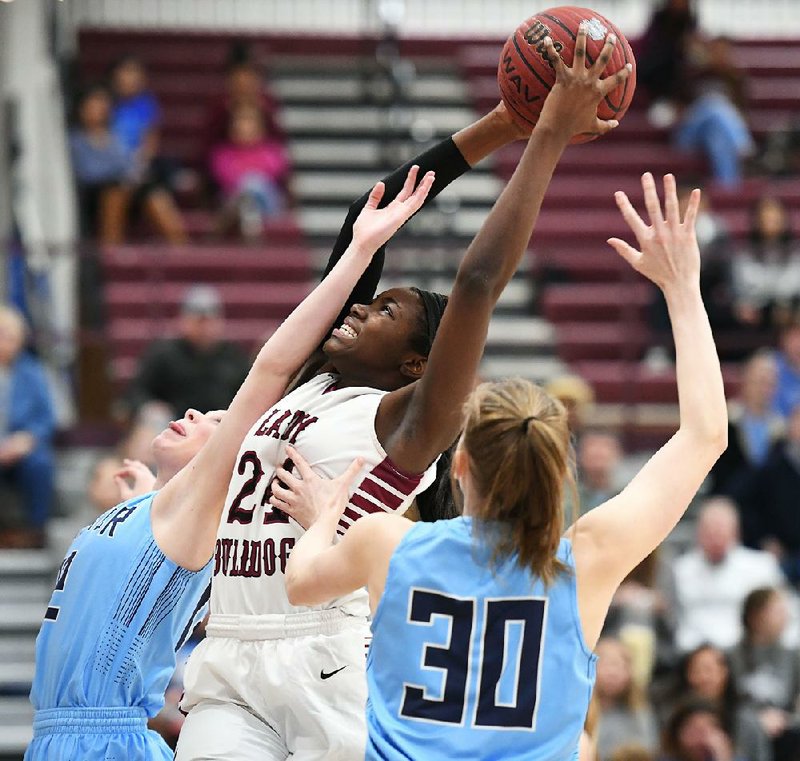Springdale High’s Marquesha Davis (24) comes down with a rebound over Springdale Har-Ber’s Sophie Nelson (30) and Kennedy Fotenopolus on Tuesday in Springdale.