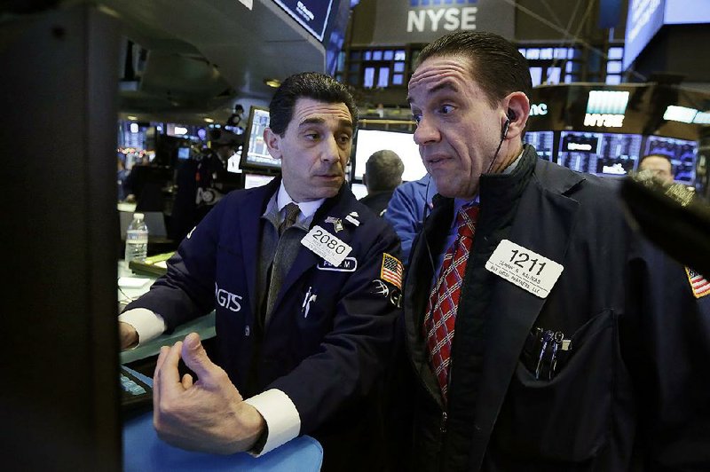 Specialist Peter Mazza (left) and trader Tommy Kalikas work Tuesday on the floor of the New York Stock Exchange. 