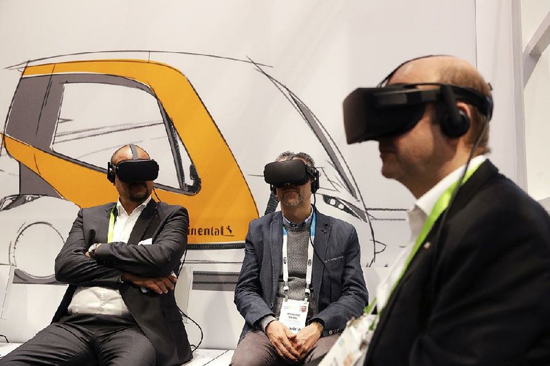 Attendees watch a presentation wearing virtual-reality headsets at the technology company Continental’s booth at the CES International gadget show Tuesday in Las Vegas. 
