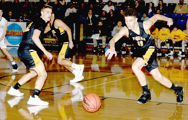 MARK HUMPHREY ENTERPRISE-LEADER Prairie Grove guards Will Pridmore (left) and D.J. Pearson (right) scramble after a loose ball. Pearson scored 22 and Pridmore had 19 as the Tigers defeated Shiloh Christian, 64-61, in a down-to-the wire game Tuesday, Jan. 2. For game details, see Page 2B in sports.