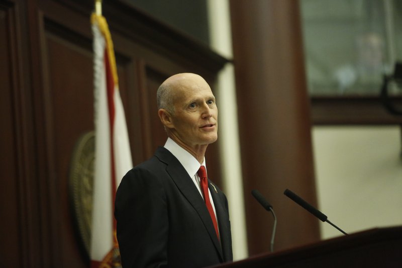 Florida Gov. Rick Scott delivers his State of the State Address in the House chambers on the opening day of the legislative session, Tuesday, Jan. 9, 2018, in Tallahassee, Fla. (Hali Tauxe/Tallahassee Democrat via AP)