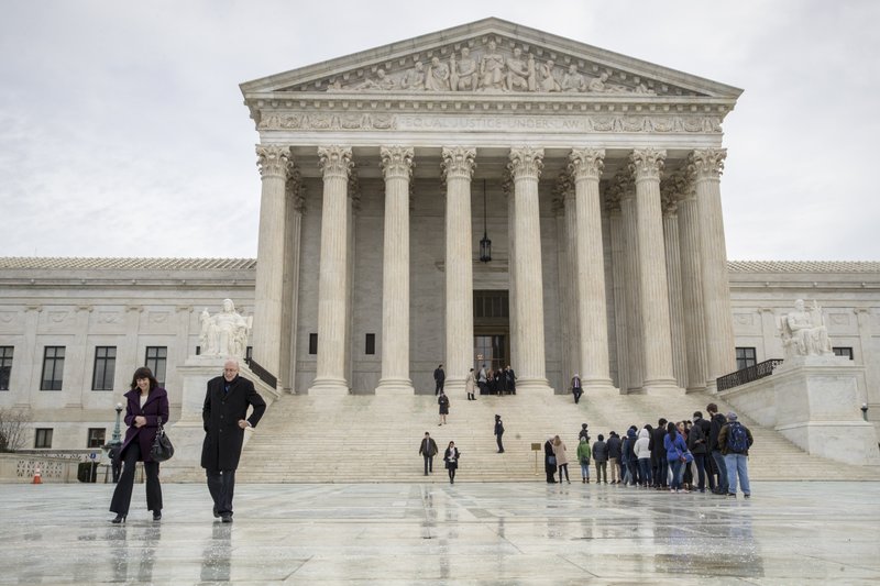 People stands on the plaza of the U.S. Supreme Court in Washington to attend arguments, Tuesday, Jan. 9, 2018. The Supreme Court is taking up a case involving the search of a rental car that lawyers say has the potential to affect the 115 million car rentals annually in the U.S. (AP Photo/J. Scott Applewhite)