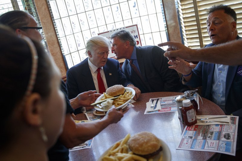 FILE - In this Sept. 12, 2016, file photo, then-Republican presidential candidate Donald Trump sits down for lunch during a visit to the Boulevard Diner in Dundalk, Md. President Donald Trump is getting his first medical checkup since taking office, a head-to-toe exam as questions swirl about the health and fitness of the oldest person ever elected to the nation's highest office. (AP Photo/Evan Vucci, File)