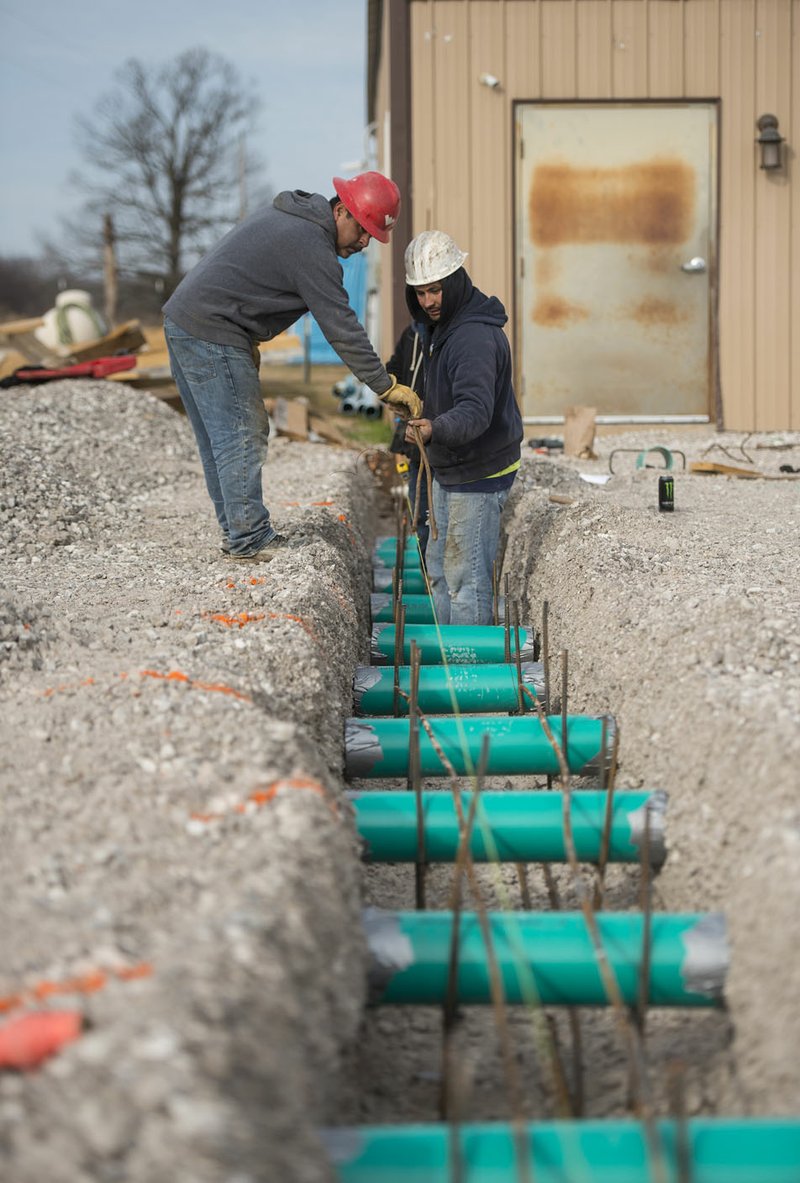 Macario Cadena (left) and Juan Perez with Verzani Construction of Bella Vista lay rebar for footings Tuesday while working on the expansion at the Centerton Animal Shelter.