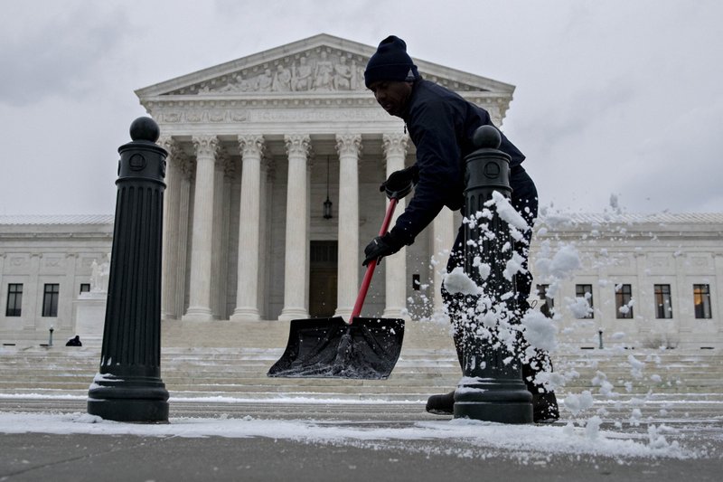 Bloomberg /ANDREW HARRER An Architect of the Capitol employee shovels snow in front of the U.S. Supreme Court in Washington on Jan. 4, 2018.