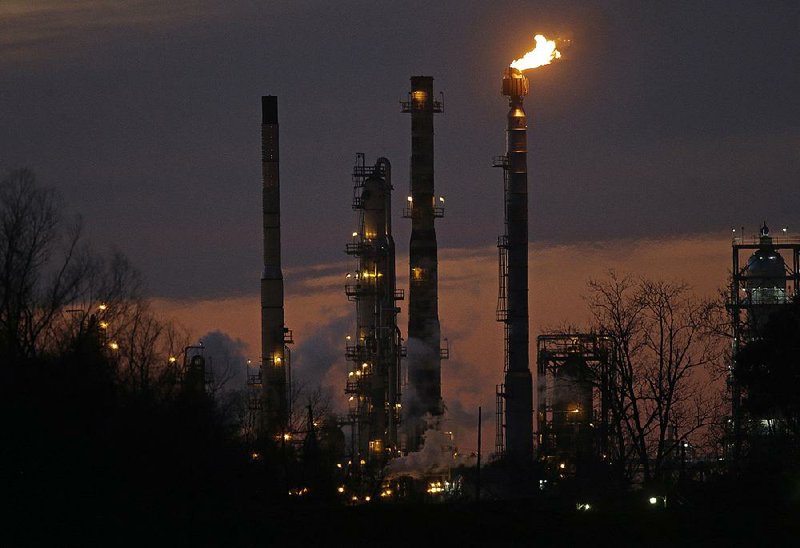 An Exxon Mobil refinery is seen at dusk in St. Bernard Parish, La., in 2015. Exxon is among oil companies targeted by New York City’s lawsuit claiming producers are responsible for damage related to climate change. 
