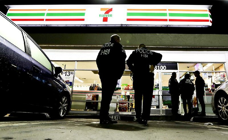 U.S. Immigration and Customs Enforcement agents serve an employment-audit notice at a 7-Eleven store early Wednesday in Los Angeles, one of about 100 such raids conducted across the country. 