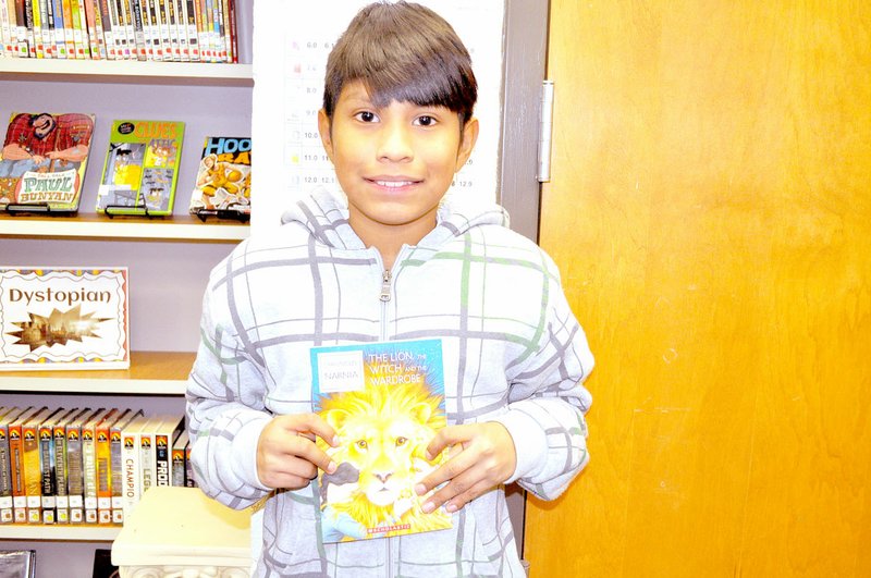 RACHEL DICKERSON/MCDONALD COUNTY PRESS Christian Rubio, fifth-grader at Noel Elementary, is pictured with &quot;The Lion, the Witch and the Wardrobe,&quot; the book for this year's One Book, One County countywide read-along.