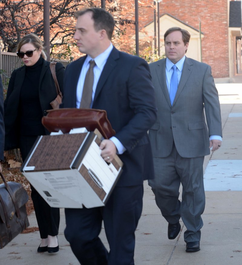 Former state Sen. Jon Woods (right), surrounded by members of his legal team, walks Nov. 30 into the John Paul Hammerschmidt Federal Building in Fayetteville.