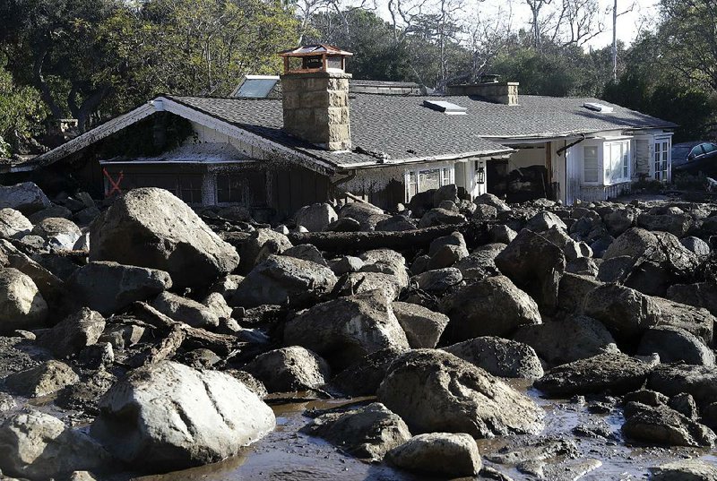 Large, muddy rocks sit in front of a house in Montecito, Calif., on Thursday as rescue workers search the muck for victims or survivors of this week’s rain-triggered landslides. 