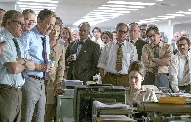 Howard Simons (David Cross), Frederick “Fritz” Beebe (Tracy Letts), Ben Bradlee (Tom Hanks), Kay Graham (Meryl Streep), Arthur Parsons (Bradley Whitford), Chalmers Roberts (Philip Casnoff), Paul Ignatius (Brent Langdon), Meg Greenfi eld (Carrie Coon, seated) and other newspaper staff members watch for breaking TV news in Steven Spielberg’s The Post.
