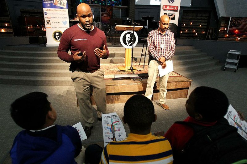 Edmond Davis (left) and Little Rock police detective Antwoine Hudson talk with kids about respectful interactions with officers during Thursday’s life-skills gathering at South City Church. 