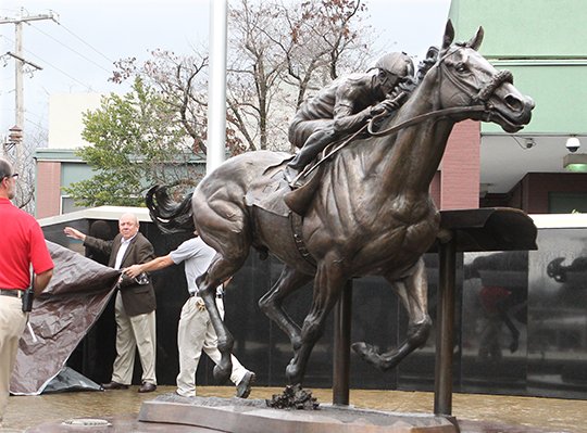Oaklawn Park employees unveil a bronze sculpture of Triple Crown winner American Pharoah during the official ribbon-cutting ceremony in 2018. - File photo by The Sentinel-Record