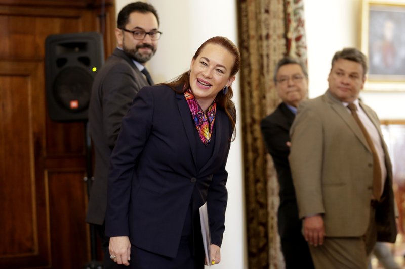 Ecuador's Foreign Minister Maria Fernanda Espinosa, front, smiles with reporters after giving a press conference in Quito, Ecuador, Thursday, Jan. 11, 2018. Ecuador has granted citizenship to WikiLeaks founder Julian Assange, who has been living in asylum at the nation's embassy in London for more than five years. (AP Photo/Dolores Ochoa)