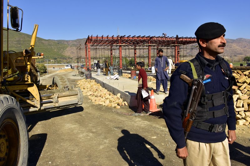 In this Dec. 22, 2017, photo, a Pakistani police officer stands guard at the site of Pakistan China Silk Road in Haripur, Pakistan. From Pakistan to Tanzania to Hungary, projects under Chinese President Xi Jinping's signature &quot;Belt and Road Initiative&quot; are being canceled, renegotiated or delayed due to disputes about costs or complaints host countries get too little out of projects built by Chinese companies and financed by loans from Beijing that must be repaid. (AP Photo/Aqeel Ahmed)