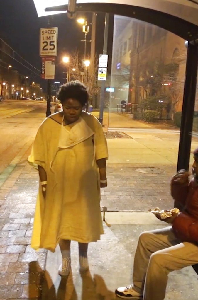 Imamu Baraka via AP This Tuesday, Jan. 9, 2018, still image taken from video provided by Imamu Baraka shows a woman discharged from a Baltimore hospital wearing only a gown and socks on a cold winter's night. Baraka, identified in local reports as the person who sought to help the woman, told The Associated Press he was so angry he decided to record Tuesday night's events on cellphone video, fearing no one would believe him if he reported a woman being left at a bus stop like that.