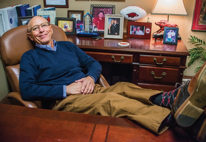 Bryant City Councilman Jerry Henson shows off his Arkansas Razorback socks in his office at Old South Realty in Benton. Henson, who was diagnosed with stage 4 liver cancer a month ago, was presented with the Charles Broadway Community Excellence Award on Dec. 19. 