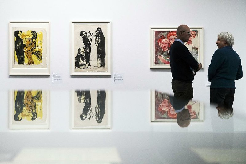 Visitors talk in front of Junges Paar (left) and Diskussion by Emil Nolde in an exhibit of what Nazis called “degenerate art” at the Kunstmuseum in Bern.