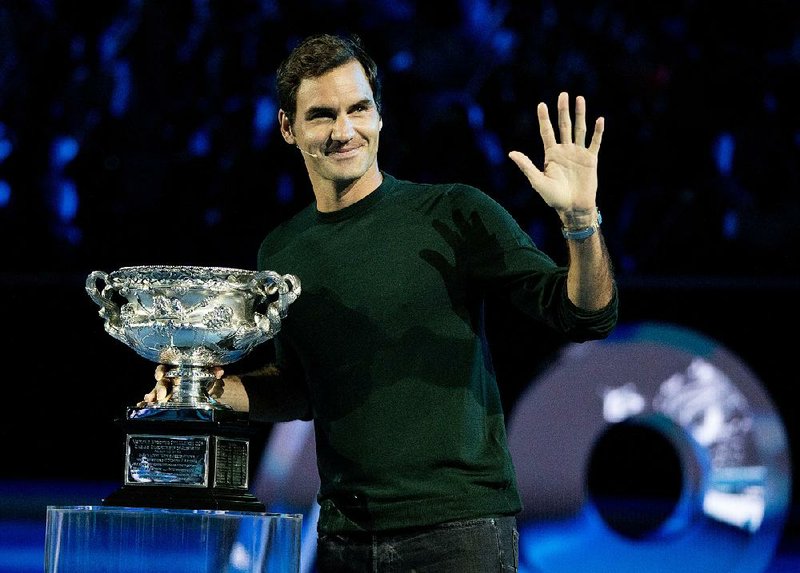 Defending men's singles champion Switzerland's Roger Federer waves to the crowd during a ceremony for the official draw at the Australian Open tennis championships in Melbourne, Australia Thursday, Jan. 11, 2018. 