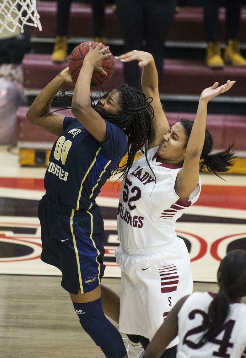 Kearah Conley (52) of Springdale fouls Shania Wilson (00) of Bentonville West as she shoots in Springdale’s 56-53 victory Friday night in Springdale.