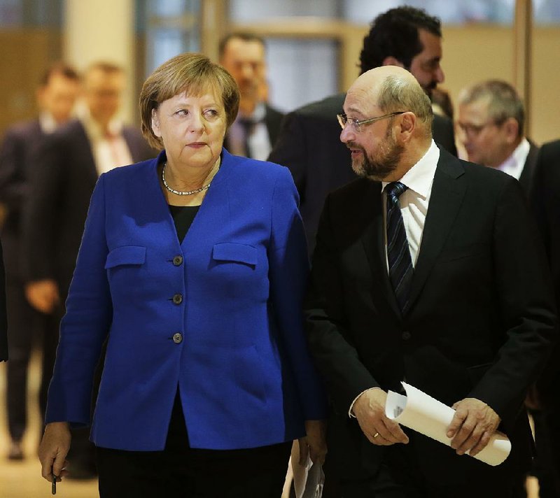 German Chancellor Angela Merkel and Social Democratic Party leader Martin Schulz arrive for a news conference Friday in Berlin regarding a possible deal for a coalition government. 