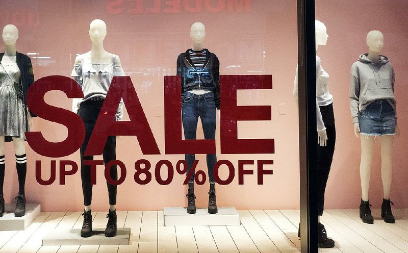 An H&M store window advertises a sale at a mall in New York City. Consumer inflation rose just 0.1 percent in December, the smallest gain since October. 