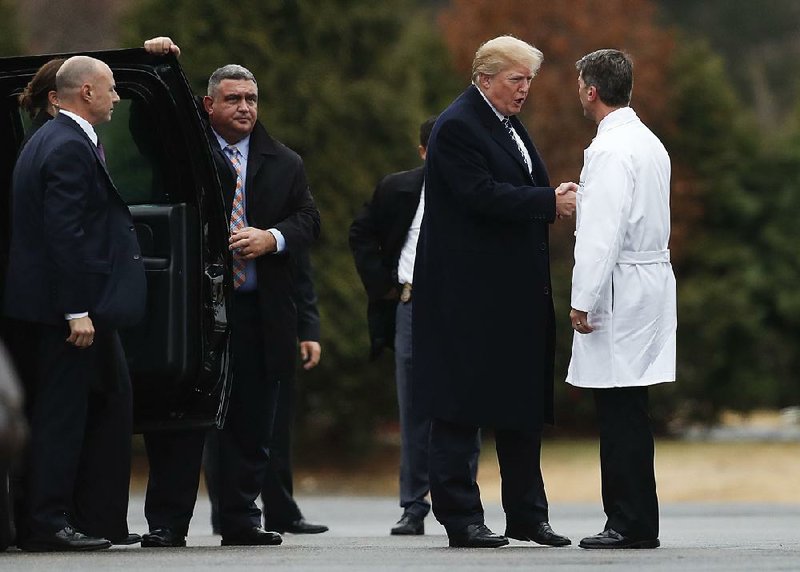 President Donald Trump shakes hands with White House physician Ronny Jackson as he leaves Walter Reed military hospital in Bethesda, Md., on Friday after undergoing a medical checkup. In a statement released later by the White House, Jackson said Trump was in excellent health.  