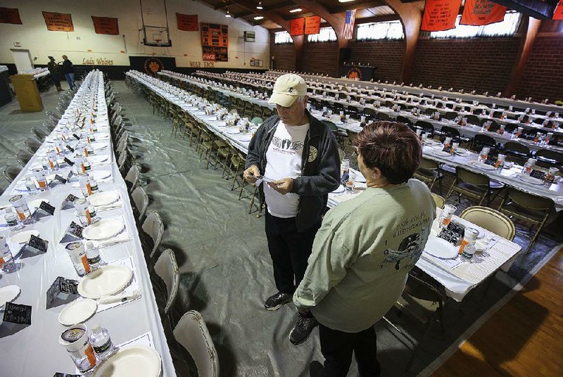 Jon Howell (left) and Christy Murphy set up tables and chairs Friday at the gym in Gillett as the town gets ready for the 75th annual coon supper. 