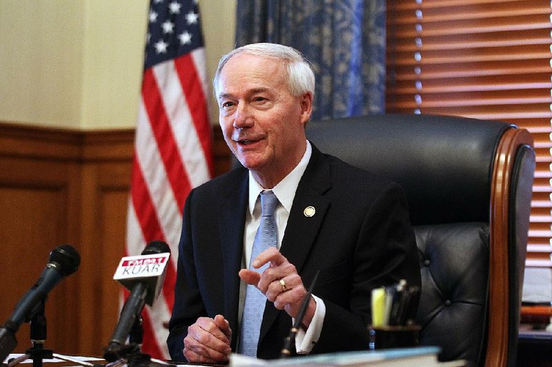Governor Asa Hutchinson (left) talks about shrinking Medicare costs on Thursday, Jan. 4, 2018, at the State Capitol in Little Rock. 