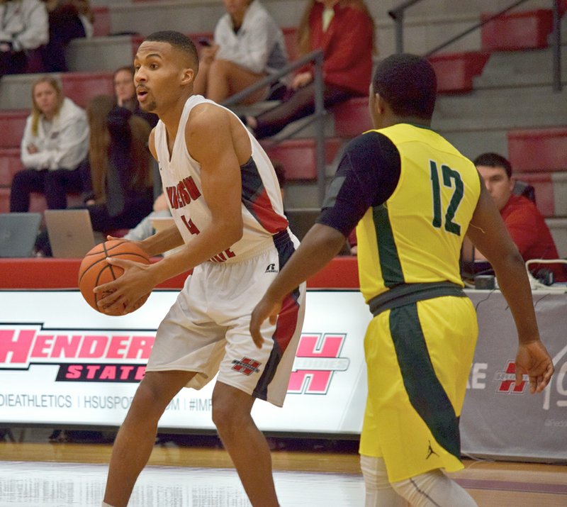 Submitted photo REDDIE TO PASS: Henderson State junior guard Josh Jones (4) looks to pass as Arkansas Tech's Freddy Lee (12) defends Thursday night at the Duke Wells Center. Jones finished with 20 points, seven rebounds and three assists in a 106-96 win by the Reddies.
