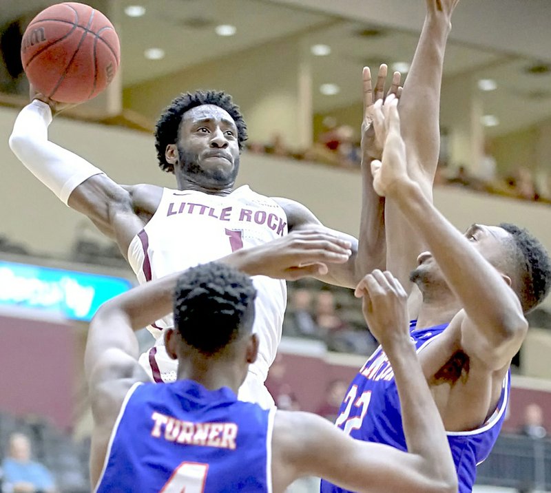 Submitted photo WITH AUTHORITY: Sophomore guard Andre Jones (1), a graduate of Malvern, rises for a score over UT-Arlington defenders Davion Turner (4) and Link Kabadyundi (22) Thursday at the Jack Stephens Center in Little Rock. Jones scored 24 points to help the Trojans win 77-65.