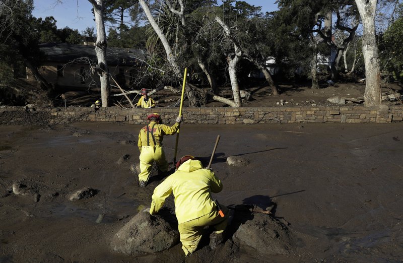 A Cal Fire search and rescue crew walks through mud near homes damaged by storms in Montecito, Calif., Friday, Jan. 12, 2018. The mudslide, touched off by heavy rain, took many homeowners by surprise early Tuesday, despite warnings issued days in advance that mudslides were possible because recent wildfires had stripped hillsides of vegetation that normally holds soil in place.
(AP Photo/Marcio Jose Sanchez)