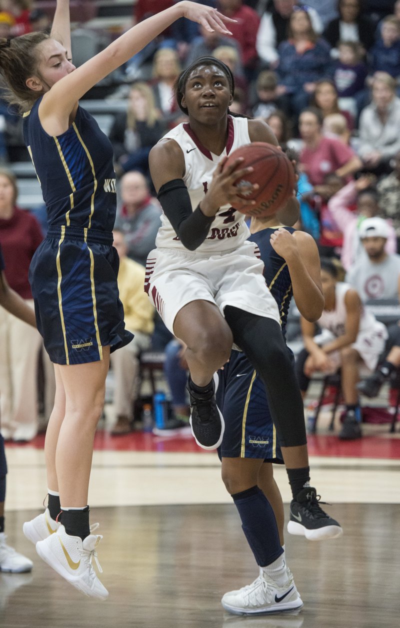Springdale High’s Marquesha Davis (24) goes up for a double-clutch layup while Alli Clifton of Bentonville West attempts to block her shot Friday at Bulldog Gymnasium in Springdale. 