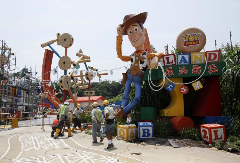 FILE - In this Sept. 8, 2011, file photo, workers walk past "Toy Story" character Woody at the construction site of the new attraction area Toy Story Land in Hong Kong Disneyland. A new 11-acre Toy Story Land is planned for Walt Disney World Resort near Orlando, Fla., in 2018, opening at the theme park's Hollywood Studios. 