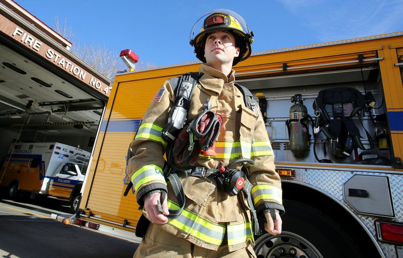 NWA Democrat-Gazette/DAVID GOTTSCHALK Dylan Poe, a Springdale firefighter, displays an air tank pack from Engine 4 at Fire Station 4 at 3420 Elm Springs Road. The city proposes three new fire stations in it's upcoming bond issue. One will be in the far northwest corner of Springdale. The area currently covered by Station 4.