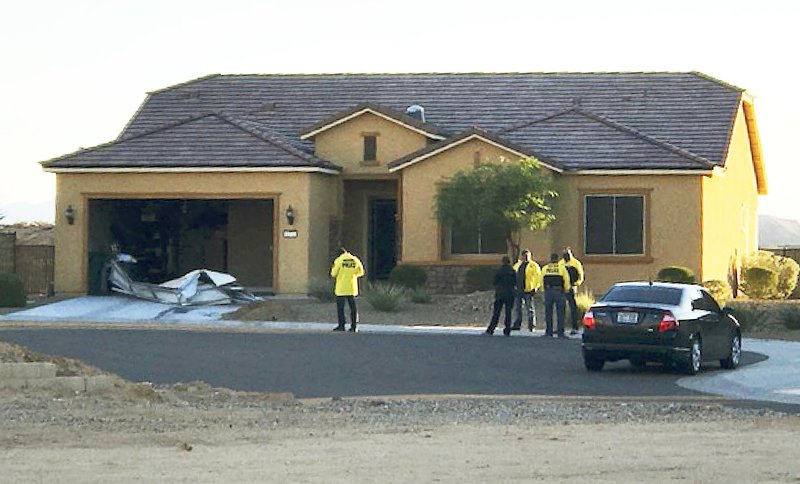 FILE - This Oct. 2, 2017 file photo provided by the Mesquite, Nev., Police Department shows police personnel stand outside the home of Stephen Paddock on Monday, Oct. 2, 2017, in Mesquite. A federal judge is being asked to unseal documents telling what federal agents learned before searching properties belonging to the gunman responsible for the Oct. 1, 2017 massacre on the Las Vegas Strip. Prosecutors aren't opposing a Friday, Jan. 12, 2018 request from media organizations for U.S. District Judge Jennifer Dorsey to release redacted affidavits underlying warrants for locations including Stephen Paddock's home in Mesquite. (Mesquite Police Department via AP, File)