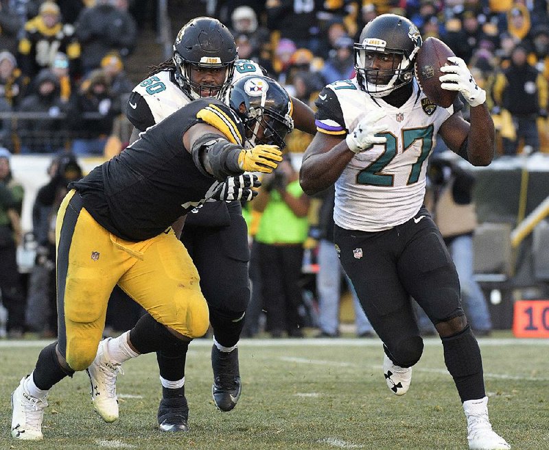 Jaguars running back Leonard Fournette (right) carries the ball with Steelers defensive end Stephon Tuitt in pursuit during the second half Sunday in Pittsburgh. Fournette finished with 109 yards rushing and three touchdowns as the Jaguars won 45-42.