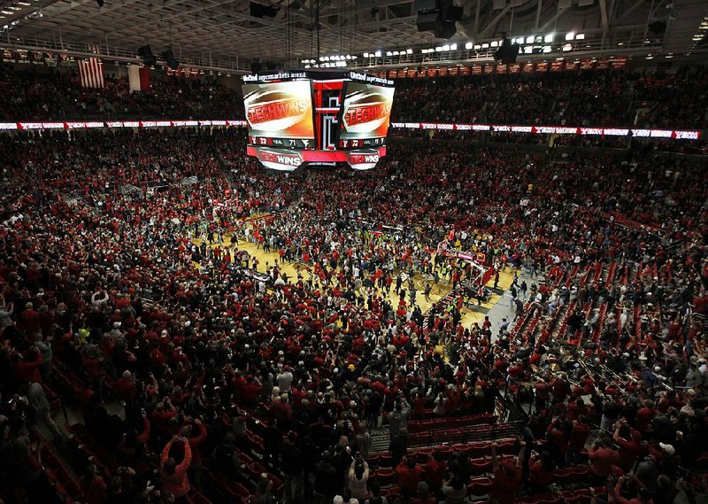 Texas Tech fans storm the court after the No. 8 Red Raiders’ 72-71 victory over No. 2 West Virginia on Saturday in Lubbock, Texas. West Virginia is investigating whether one of its players struck a Texas Texas fan during the celebration.