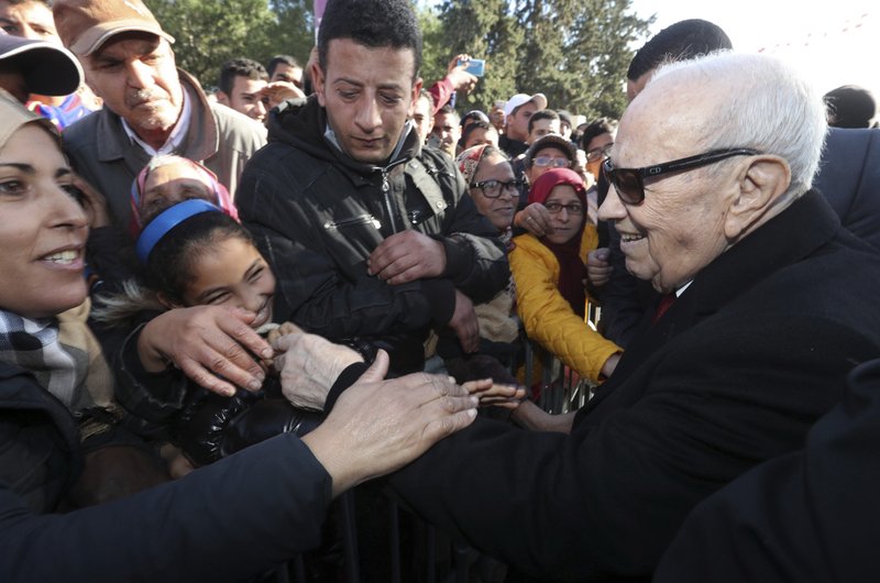 Tunisian President Beji Caid Essebsi shake hands with bystanders as he arrives for a event in Tunis, Tunisia, Sunday, Jan. 14, 2018. Tunisian authorities announced plans to boost aid to the needy in a bid to placate protesters whose demonstrations over price hikes degenerated into days of unrest across the North African nation, which is marking seven years on Sunday since its long-time autocratic ruler was driven into exile.(Slim Abid/Tunisian Presidency via AP)