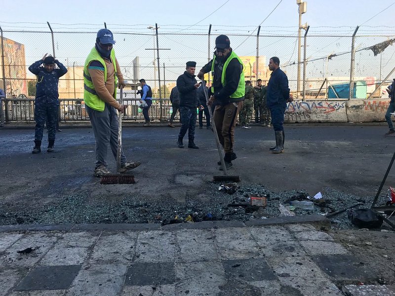 Baghdad municipality workers clean the scene of a double suicide bombing in Baghdad, Iraq, on Monday, Jan. 15, 2018.