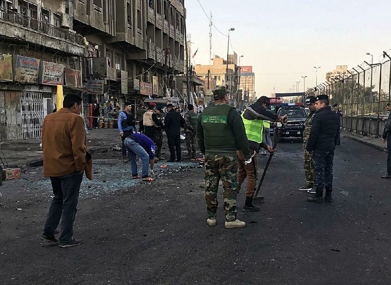 Iraqi security forces gather Monday at the scene of a double suicide bombing in Baghdad.
